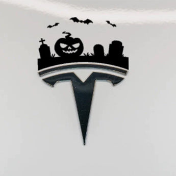 Halloween graveyard decoration sticker featuring a jack-o'-lantern, bats and tombstones above a Tesla emblem