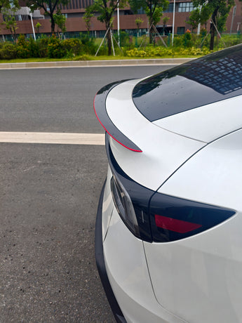 Close-up of real red carbon fiber weave on Model Y Juniper spoiler