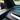 Close-up of carbon fiber weave texture on Tesla Model Y Juniper upper dashboard overlay near the blue ambient light strip