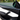 Detailed view of Tesla Model Y Juniper carbon fiber door trim showing the curved edge, woven finish and ambient light strip