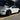 White Tesla Model Y Juniper with a carbon fiber mirror cover, black wheels and red brake calipers