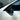 Side detail of a gloss carbon fiber mirror cover on a white Tesla Model Y Juniper, showing its curved upper contour