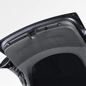 Trunk lid protector mat fitted on an open trunk lid, dark TPE with molded openings.