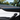 Tesla Model Y Juniper door panel featuring carbon fiber trim covers, blue ambient light strip and black armrest