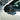 Close-up of the glossy carbon fiber weave and sculpted bull-horn shape on a Tesla Model Y Juniper mirror cover