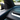 Carbon fiber upper dashboard overlay installed in Tesla Model Y Juniper with blue ambient lighting