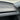 Close-up product photo of a blue and silver 3D alloy Performance badge with a distinctive starburst design for Tesla Model Y Juniper styling.