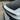 Close-up of a 3D alloy Performance badge installed on the rear liftgate of a white Tesla Model Y Juniper, below the matte carbon fiber spoiler.
