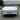 Full front view of a white Tesla Model Y Juniper Premium with gloss black Performance style fog light trim covers installed on both sides.